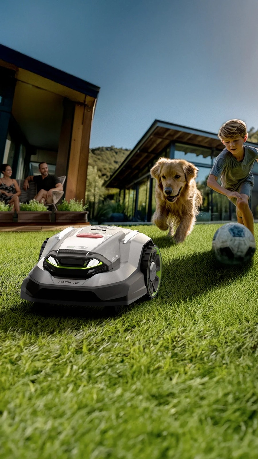 Robot lawn mower running in a garden with a family and dog nearby